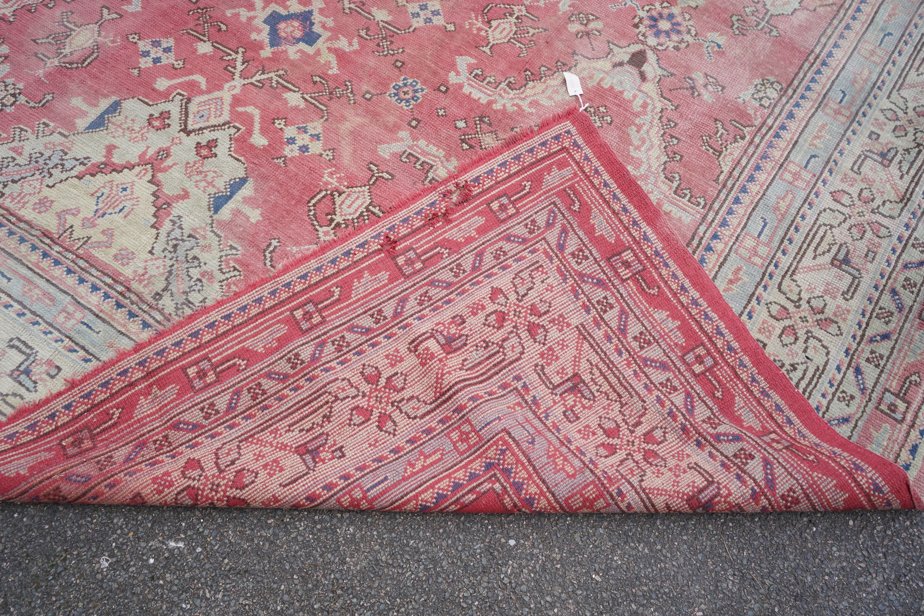 A large Turkish faded red ground carpet